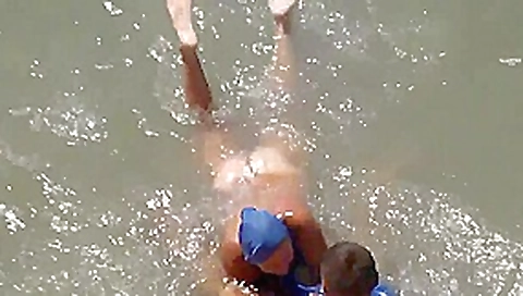 Girl sucks dick her boyfriend in the surf at a public beach